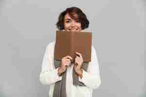 Free photo smiling young pretty woman wearing scarf reading book.