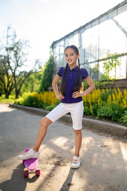 Smiling young skateboarder standing in the street