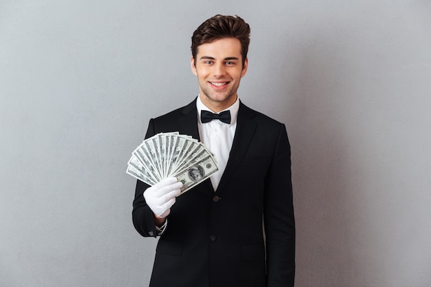 Free photo smiling young waiter holding money.