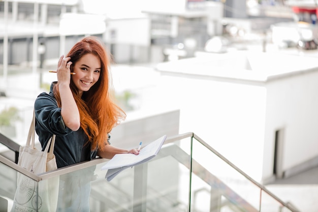 Smiling young woman adjusting hair on stairs