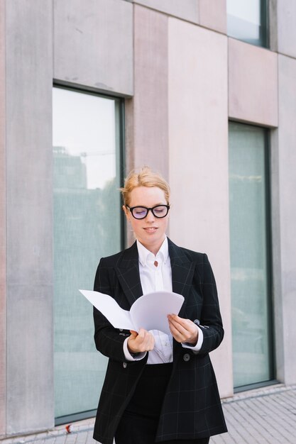 Smiling young woman checking paper document