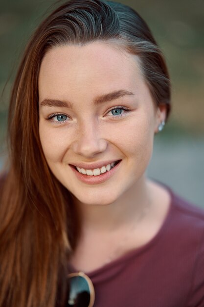 Smiling young woman closeup portrait outdoors