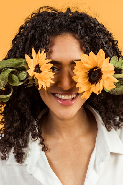 Fronte sorridente della copertura della giovane donna con i fiori