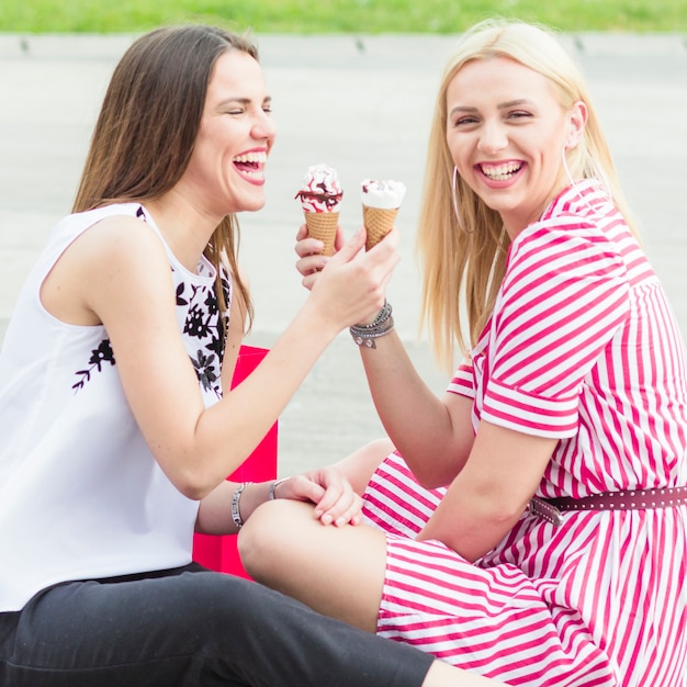 icecreamコーンを食べる笑顔の若い女性