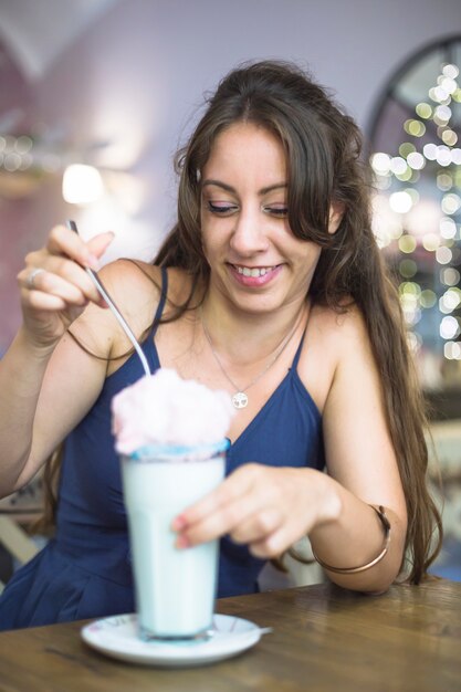 아이스크림 밀크 쉐이크를 먹고 웃는 젊은 여자