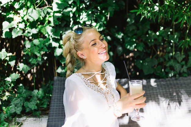 Free photo smiling young woman enjoying the drink at outdoors