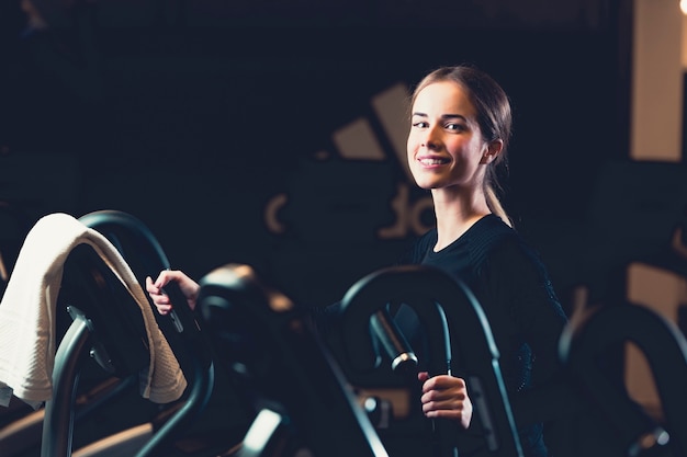 Free photo smiling young woman exercising in gym