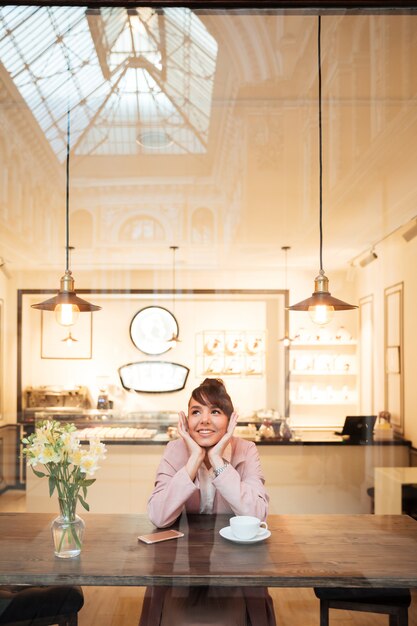 Smiling young woman having cup of coffee