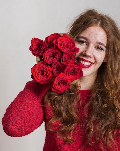 バラの花束を持って笑顔の若い女性