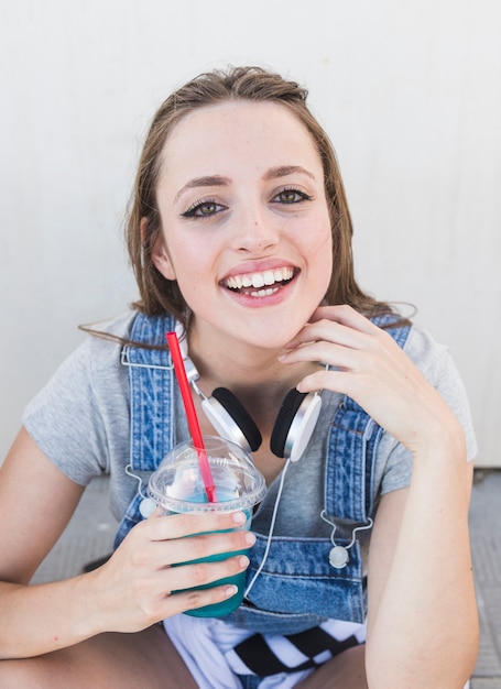 Smiling young woman holding glass of juice