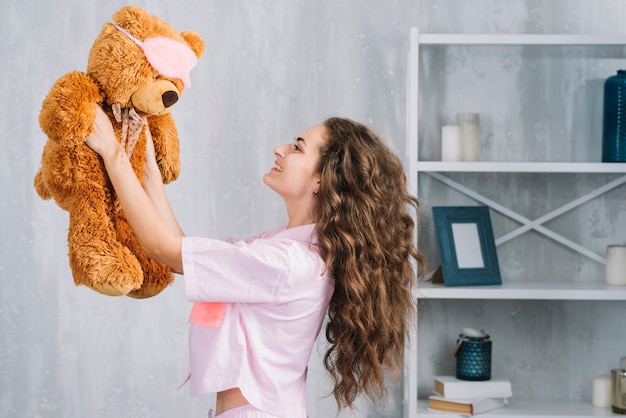 Smiling young woman holding soft toy