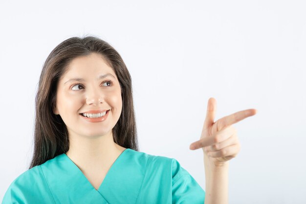 smiling young woman model pointing away .