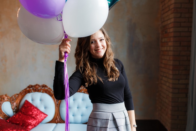 Free photo smiling young woman on party holding balloons.