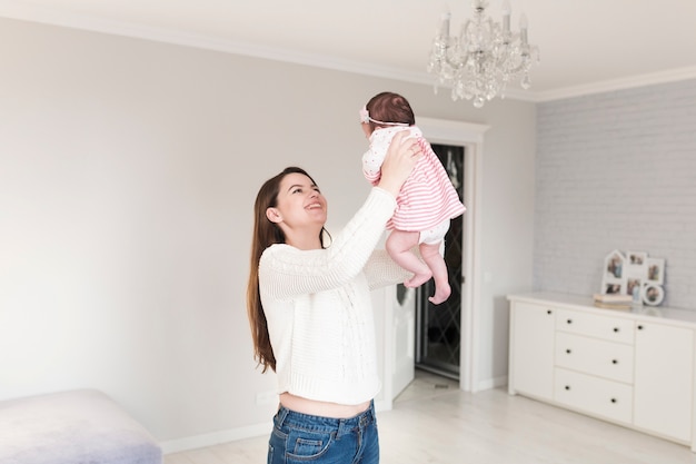 Giovane donna sorridente che gioca con il bambino