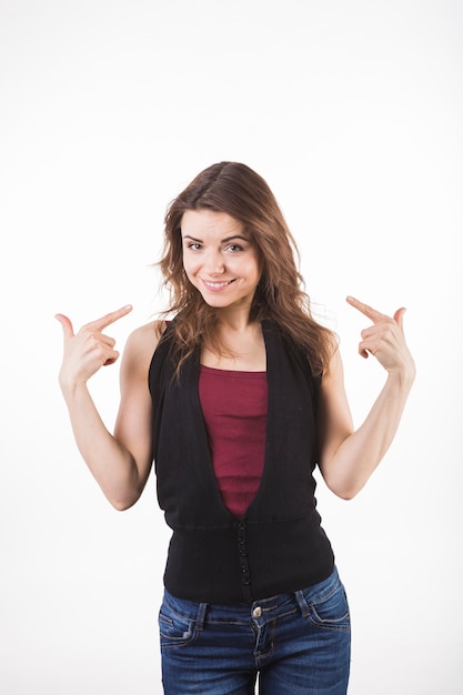 Smiling young woman pointing her index fingers toward herself