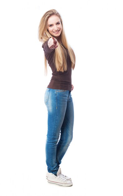 Smiling young woman pointing at you