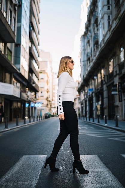 Smiling young woman on road in city