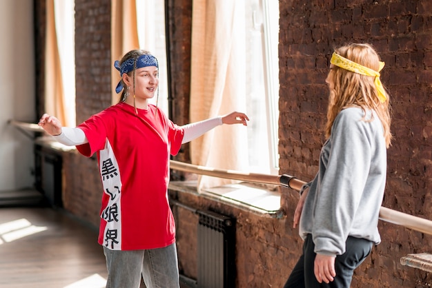 Smiling young woman showing her dance steps to her friend