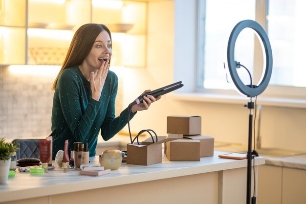 Smiling young woman showing tips on haircare and looking happy