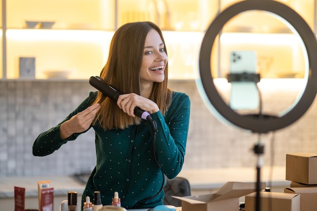 Улыбающаяся молодая женщина показывает советы по уходу за волосами