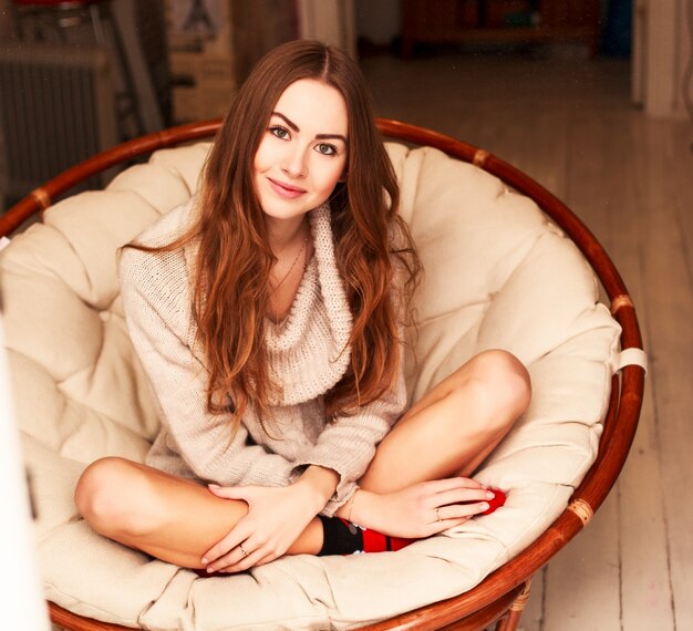 Smiling young woman sitting in armchair