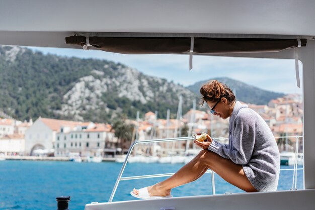 Smiling young woman sitting on yacht deck