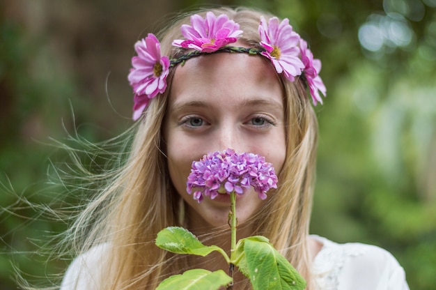 Foto gratuita sorridente giovane donna profumo di un fiore