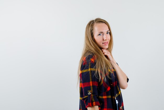 Smiling young woman turning her back to the left on white background