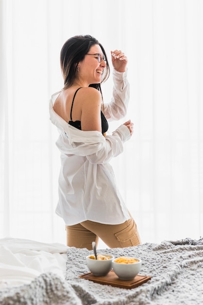 Smiling young woman with breakfast bowl on table