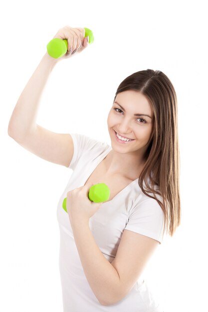 Smiling young woman with dumbbells flexing muscles