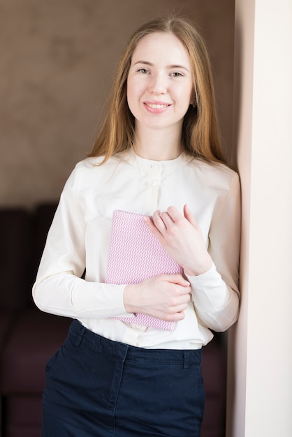 Smiling young woman with a notebook