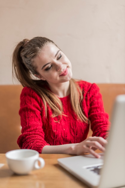 Smiling young woman working with her laptop