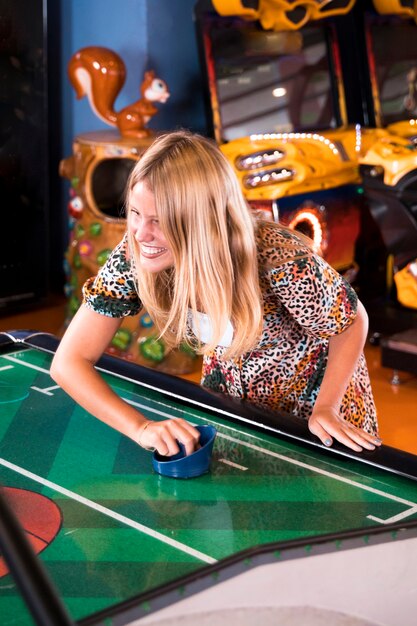 smilling woman playing air hockey
