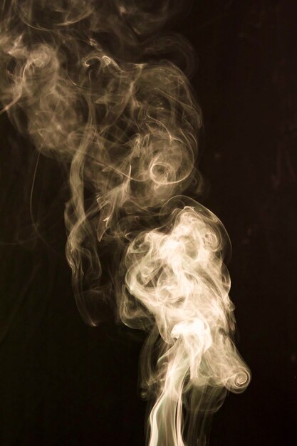Smoke spread out wide over dark background