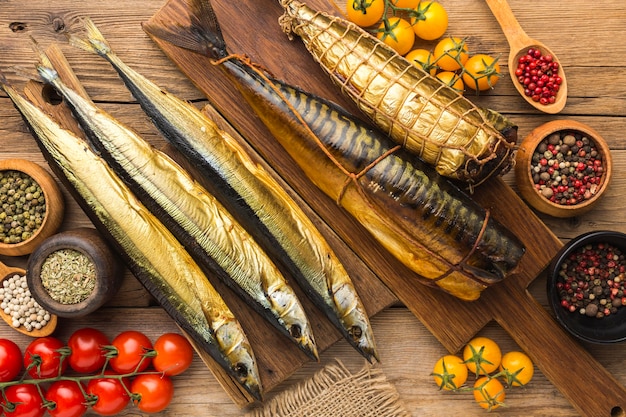 Smoked fishes on wooden table flat lay