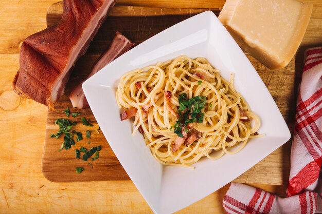 パスタの近くのスモークした肉とチーズ