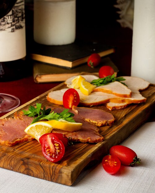 Smoked meat platter with turkey beef garnished with tomato and lemon