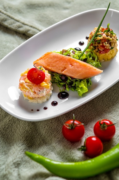 Salmone affumicato servito con insalata e bulgur a piccole porzioni