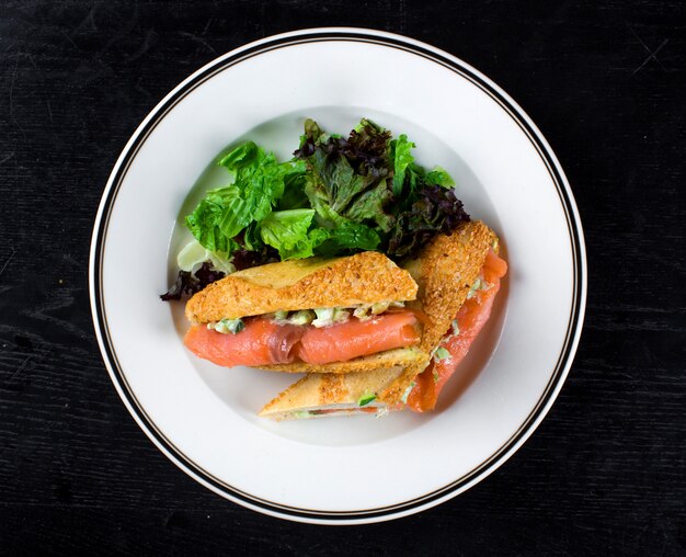 Smoked salmon wrapped in bread with side greenery