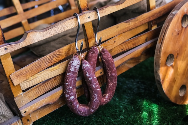 Smoked sausages on grass with wooden boxes on backside side view