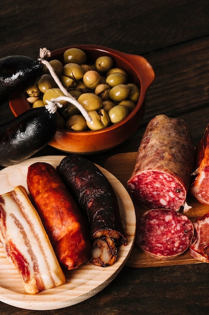 Smoked sausages near pickled olives