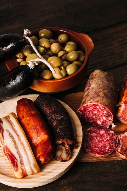 Smoked sausages near pickled olives