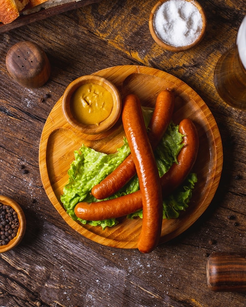 Smoked sausages served with lettuce and mustard