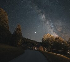 smooth road passing through the scenic countryside under the night starry sky with milky way
