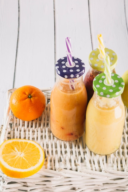 Smoothie on basket near tangerine and orange