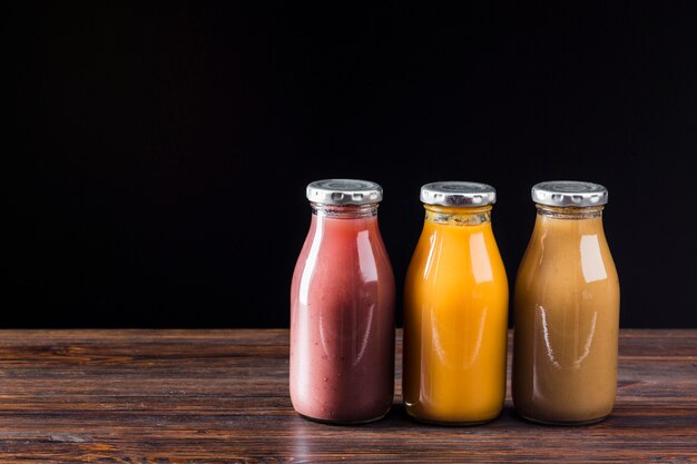 Smoothie bottles on wooden surface