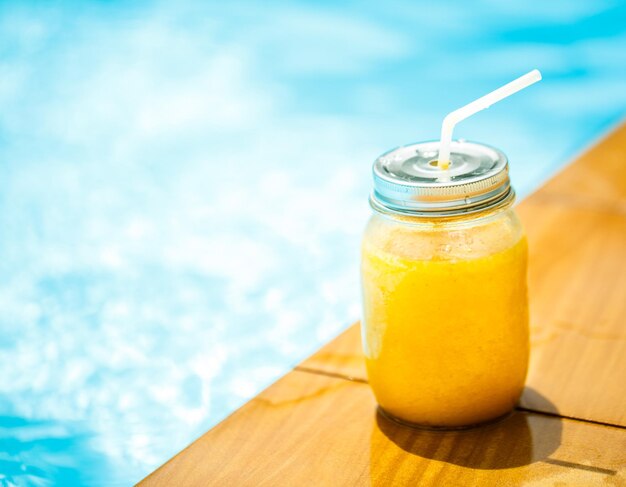 Smoothies in jar against the pool