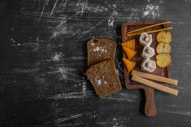 Spuntino con pane, patatine e pasticcini