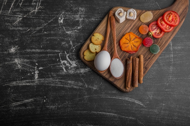 Snack board with egg, tomatoes and pastries on the top corner