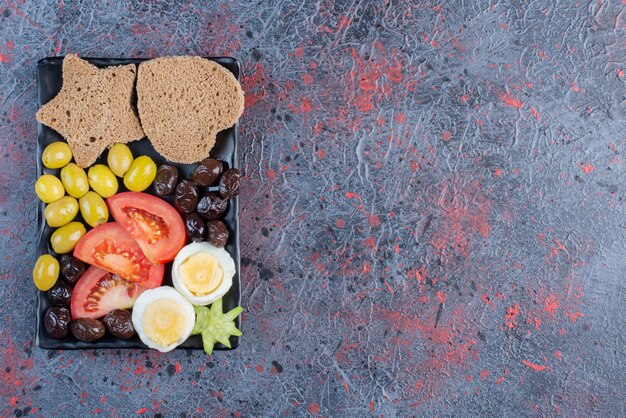 Snack board with eggs, tomato and olives. 